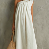 Vestido maxi blanco minimalista con un solo hombro y ambiente de resort