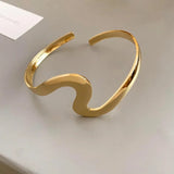 Pulsera clásica abierta con onda dorada